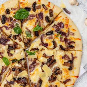 Pizza topped with mushrooms and fresh basil.