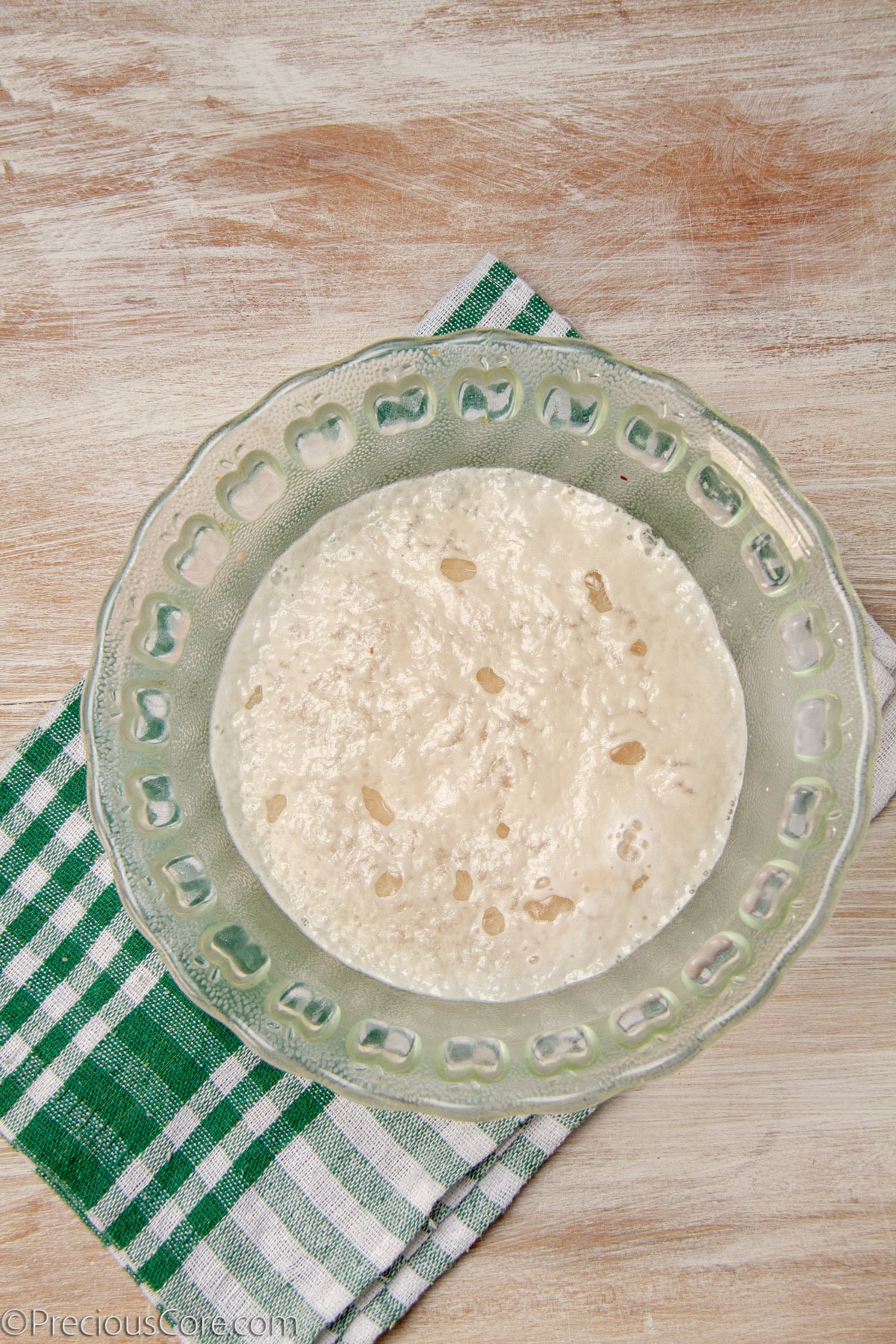 Frothy water and yeast mixture in a bowl.