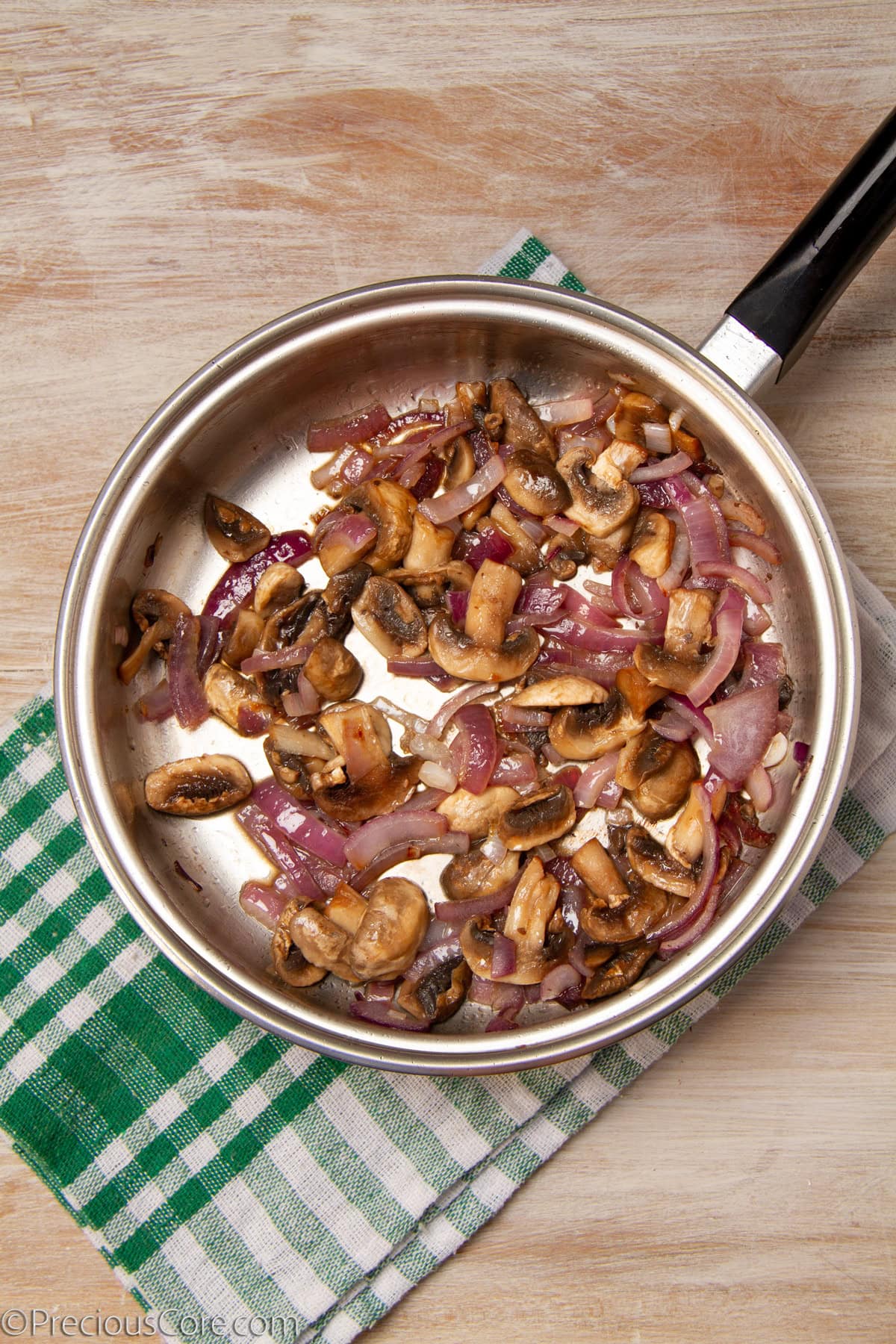 Onions and mushrooms in a pan.