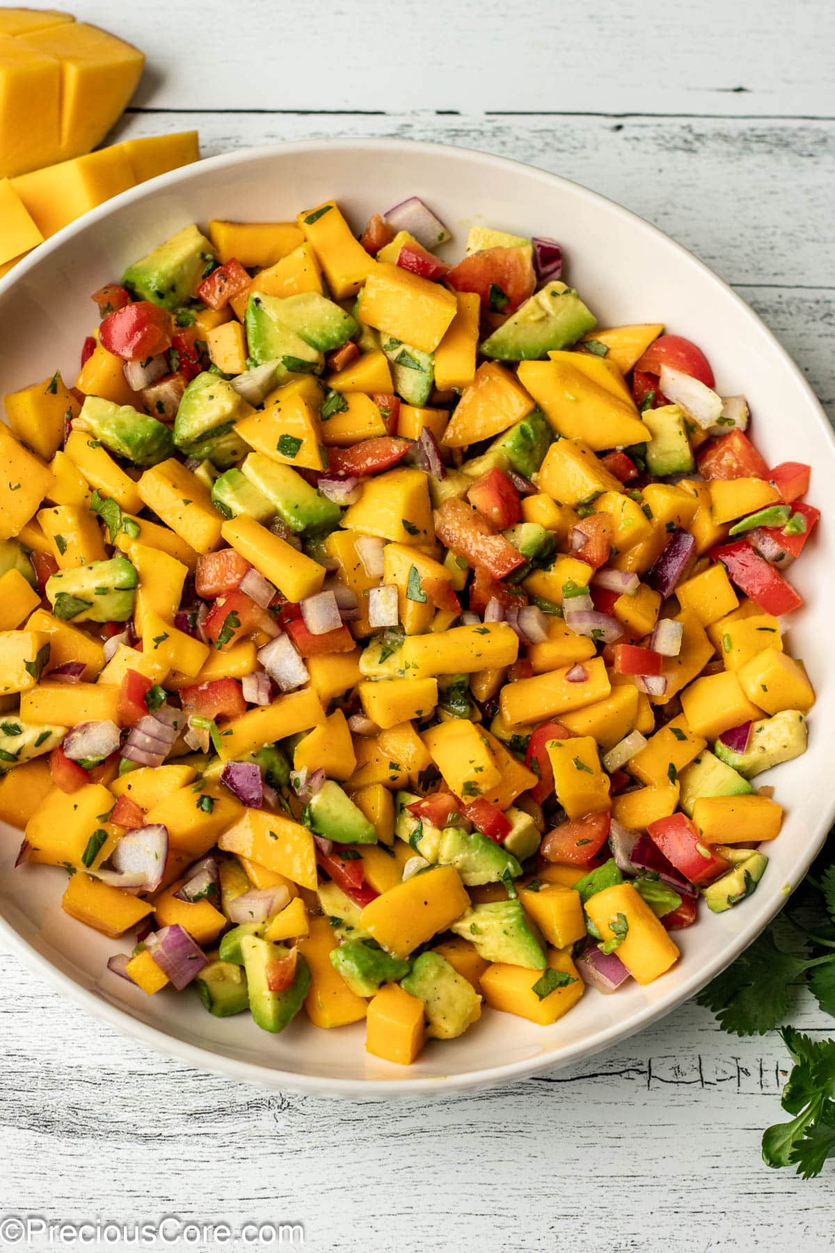 A bowl with diced mango, avocado, and other ingredients.