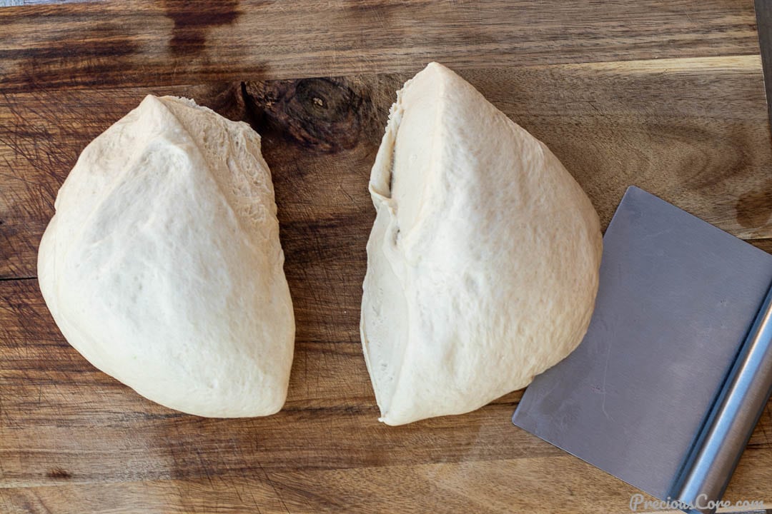 2 portions of dough on a chopping board.