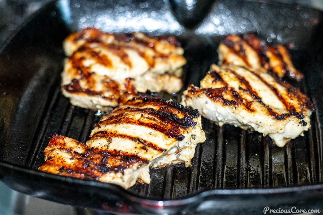 Chicken thighs grilling in grill pan.