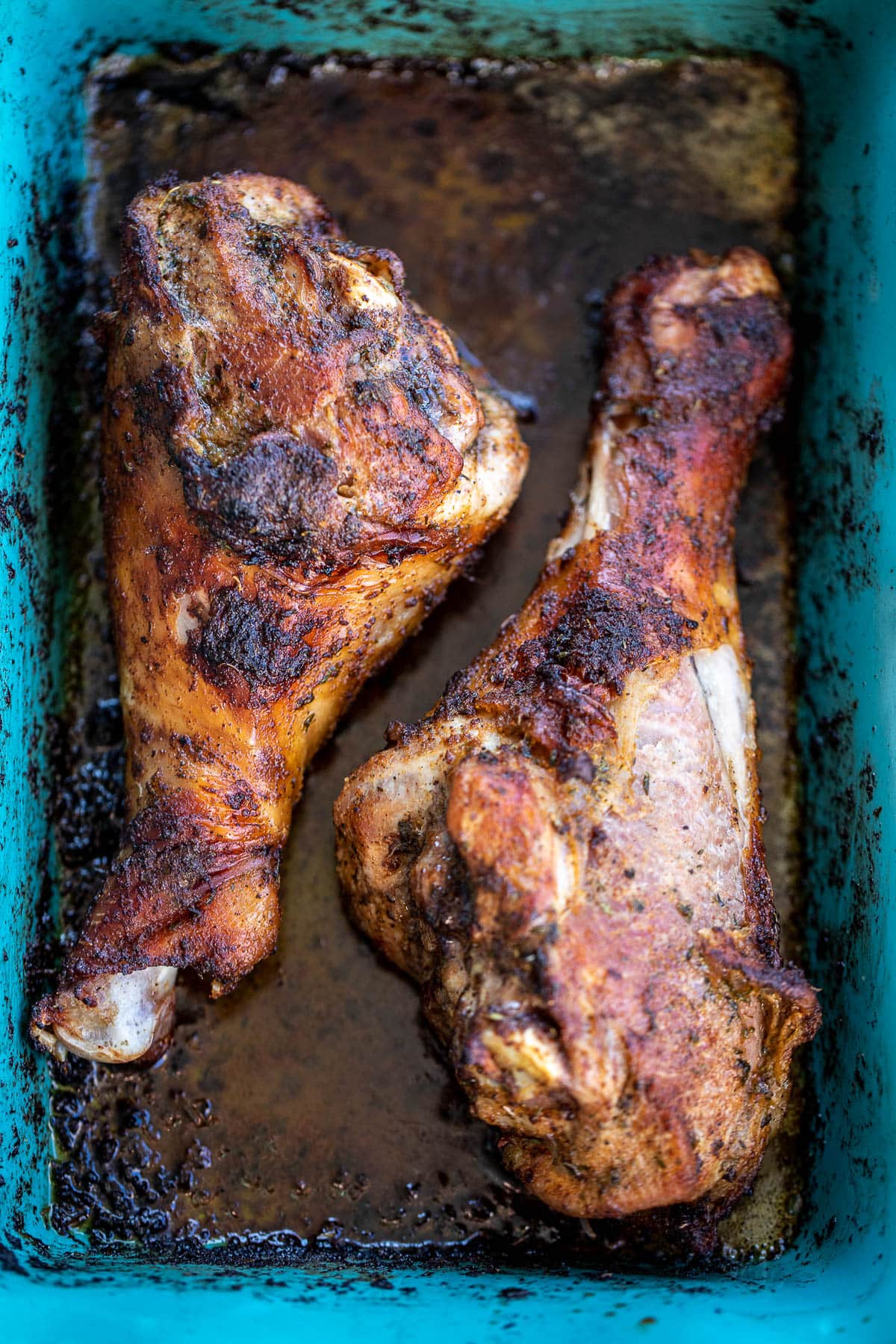 Cooked turkey legs in baking dish.