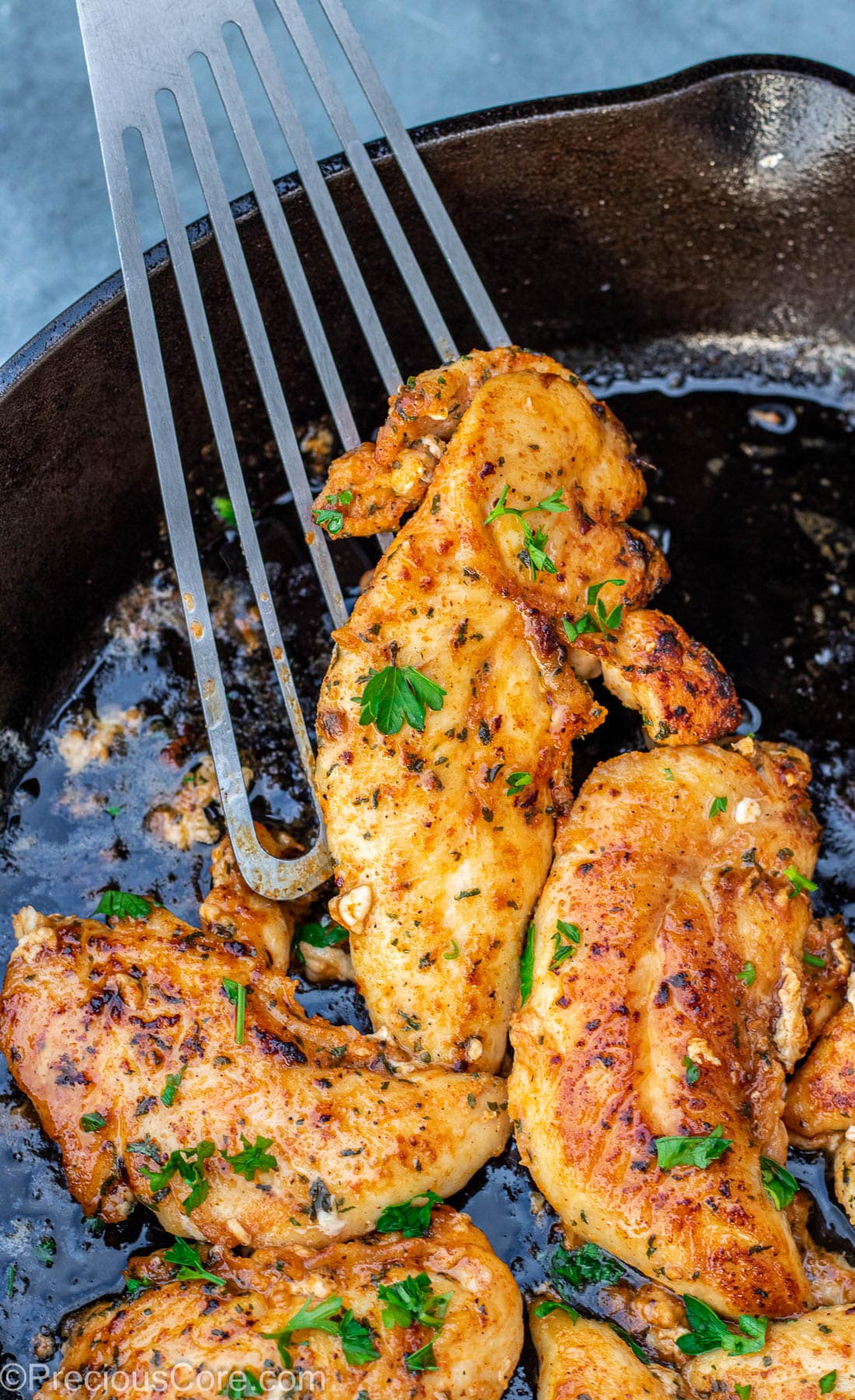 Spatula holding a cooked chicken tenderloin.