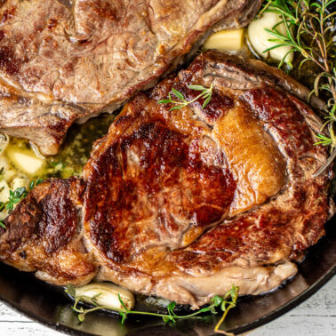 Square image of pan seared ribeye steaks.