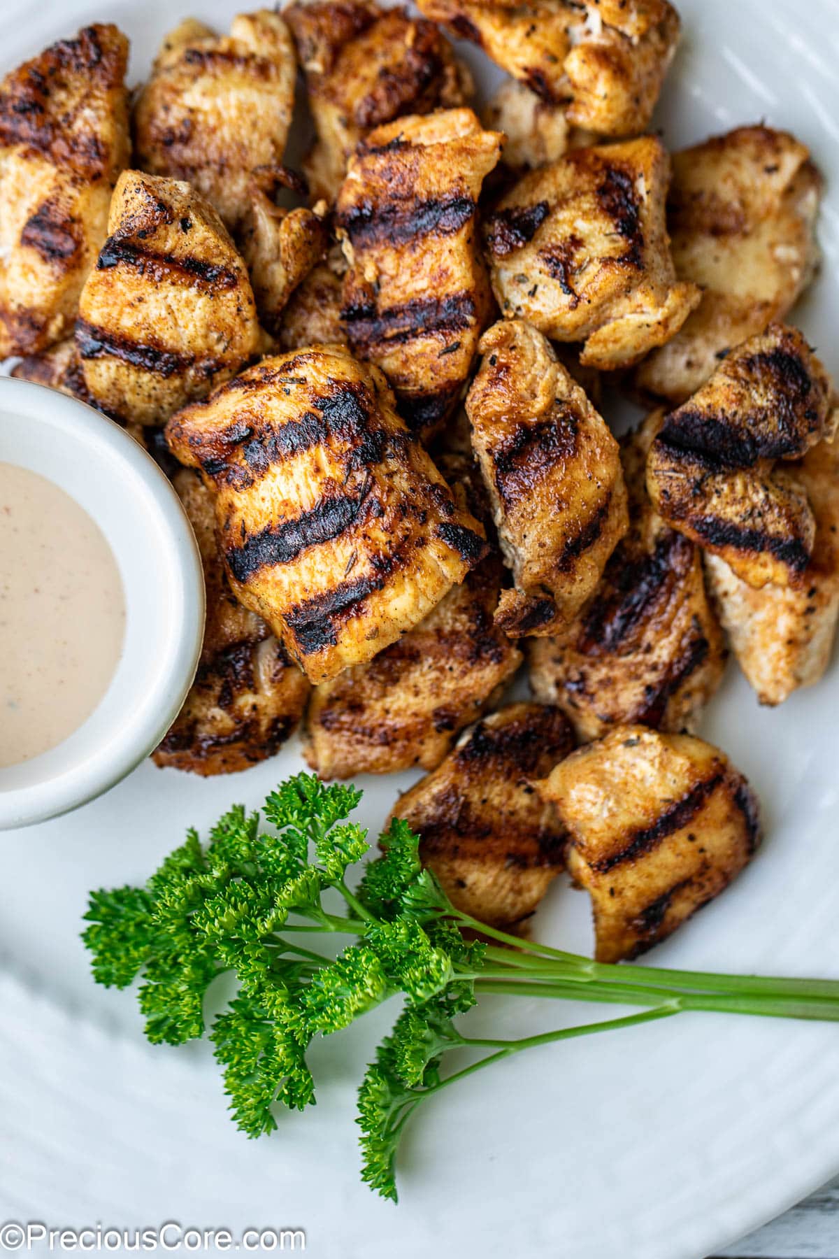 Grilled chicken nuggets with herbs and sauce.
