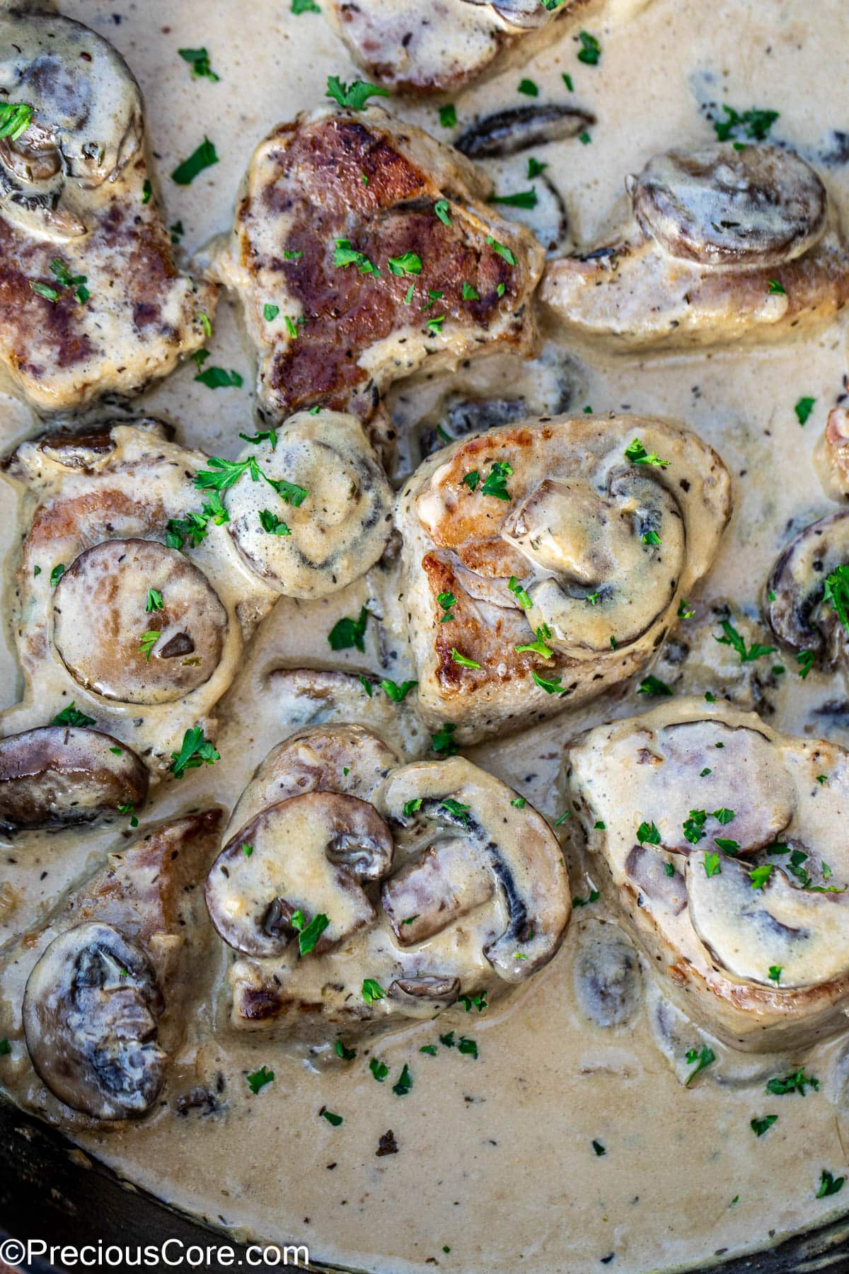Pork medallions topped with mushrooms in a savory creamy sauce.