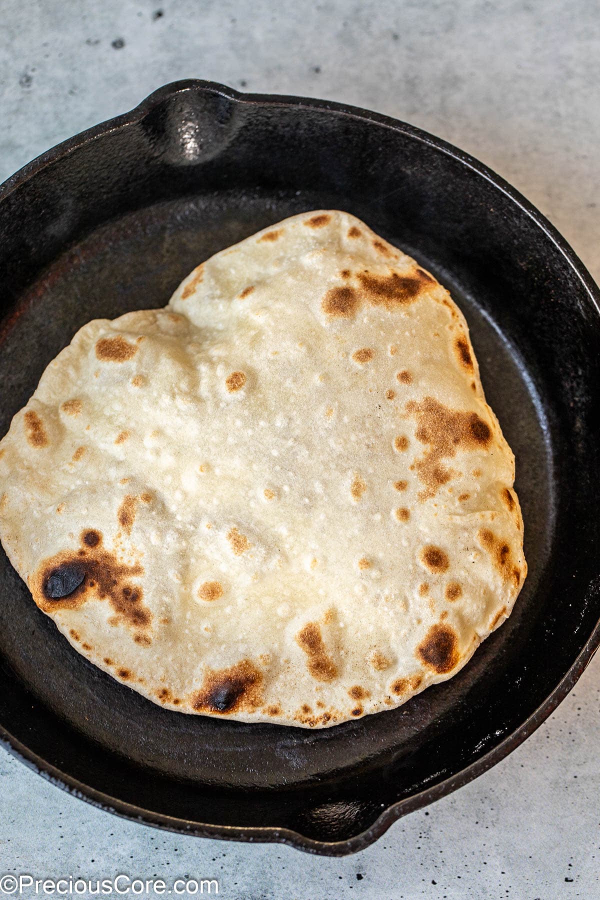 Shawarma bread puffing up in a skillet.