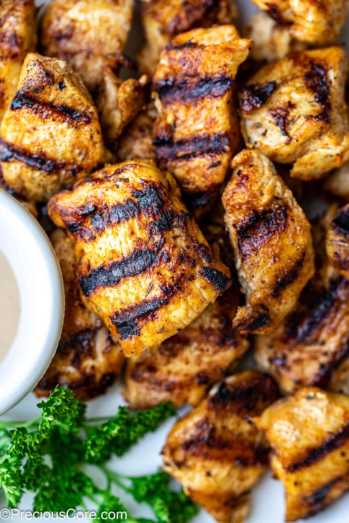 Close up shot of grilled chicken bites with grill marks.