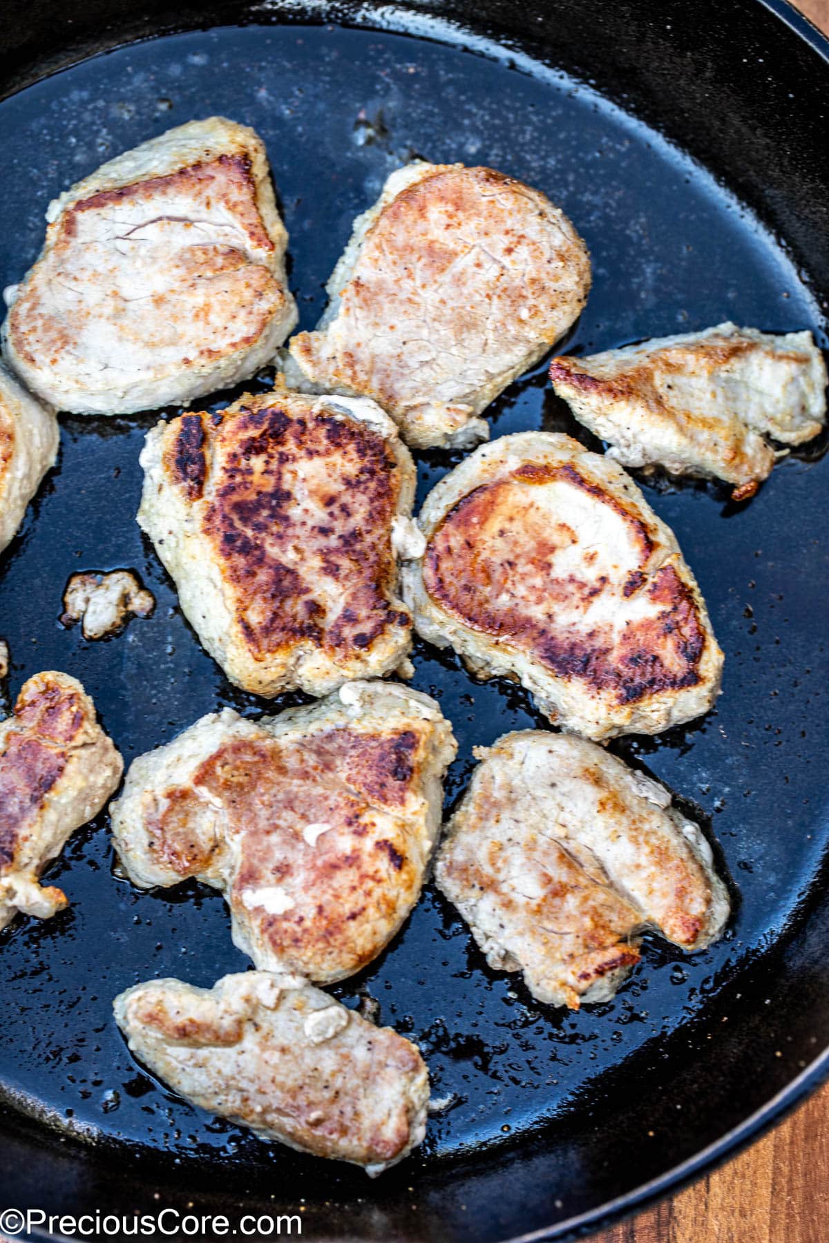 Seared pork medallions in a cast iron skillet.