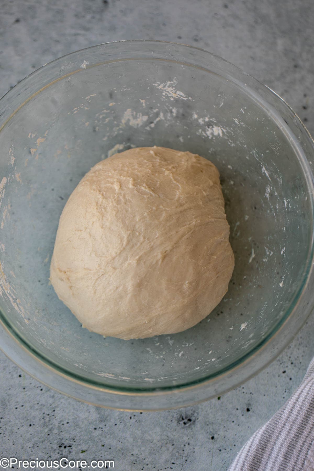 Smooth bread dough in a glass bowl.