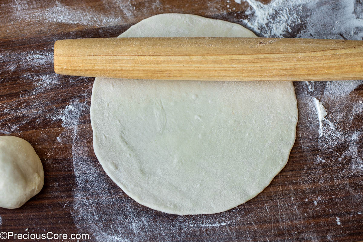 Rolling pin on rolled out dough on a floured surface.