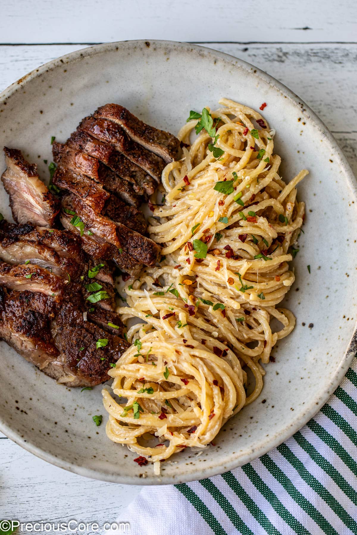 Plated steak and pasta with fresh herbs