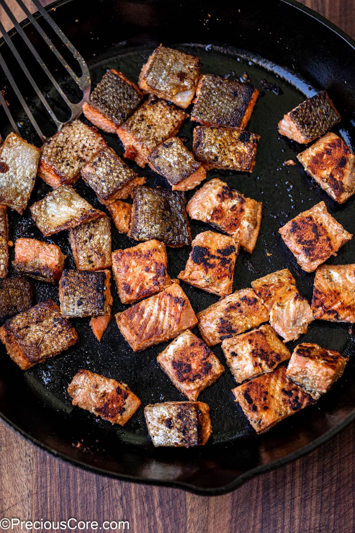 Cooking salmon in a large skillet.