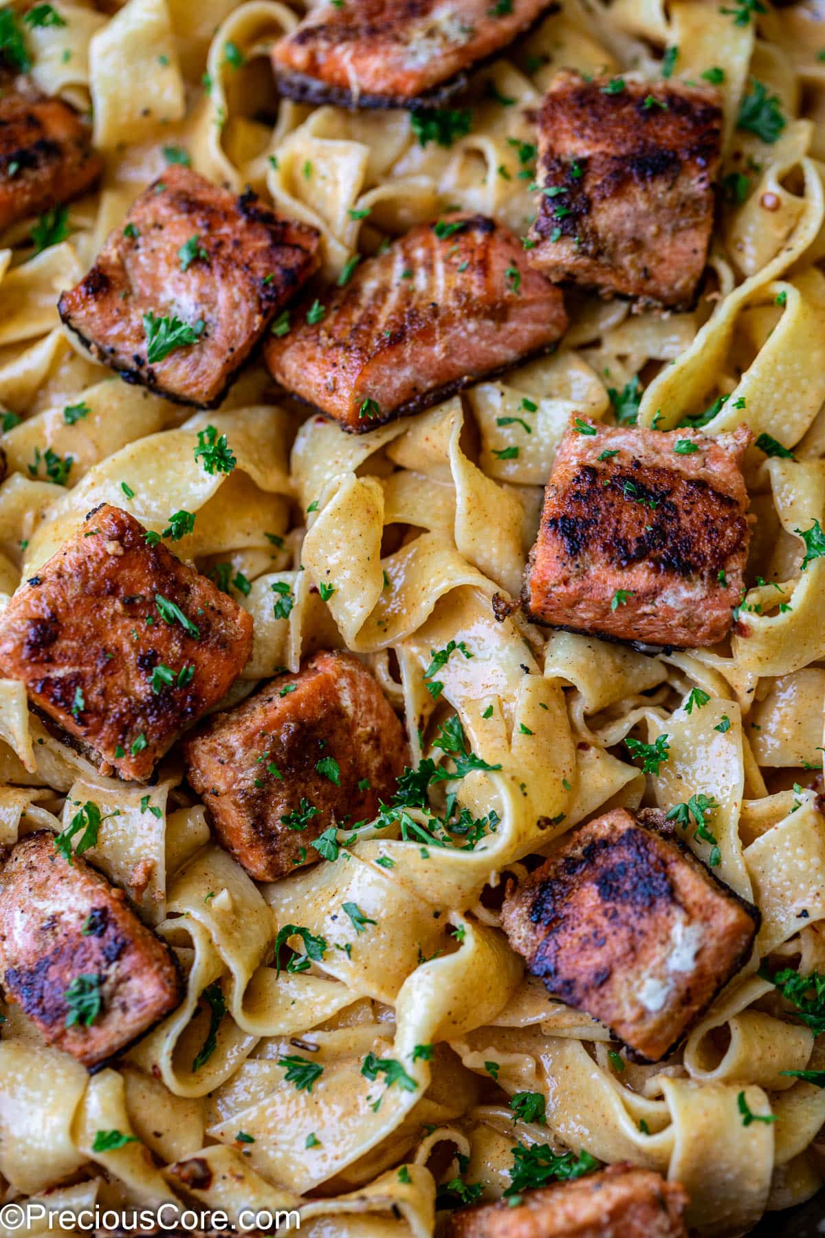 Cajun pasta with creamy sauce and salmon pieces.