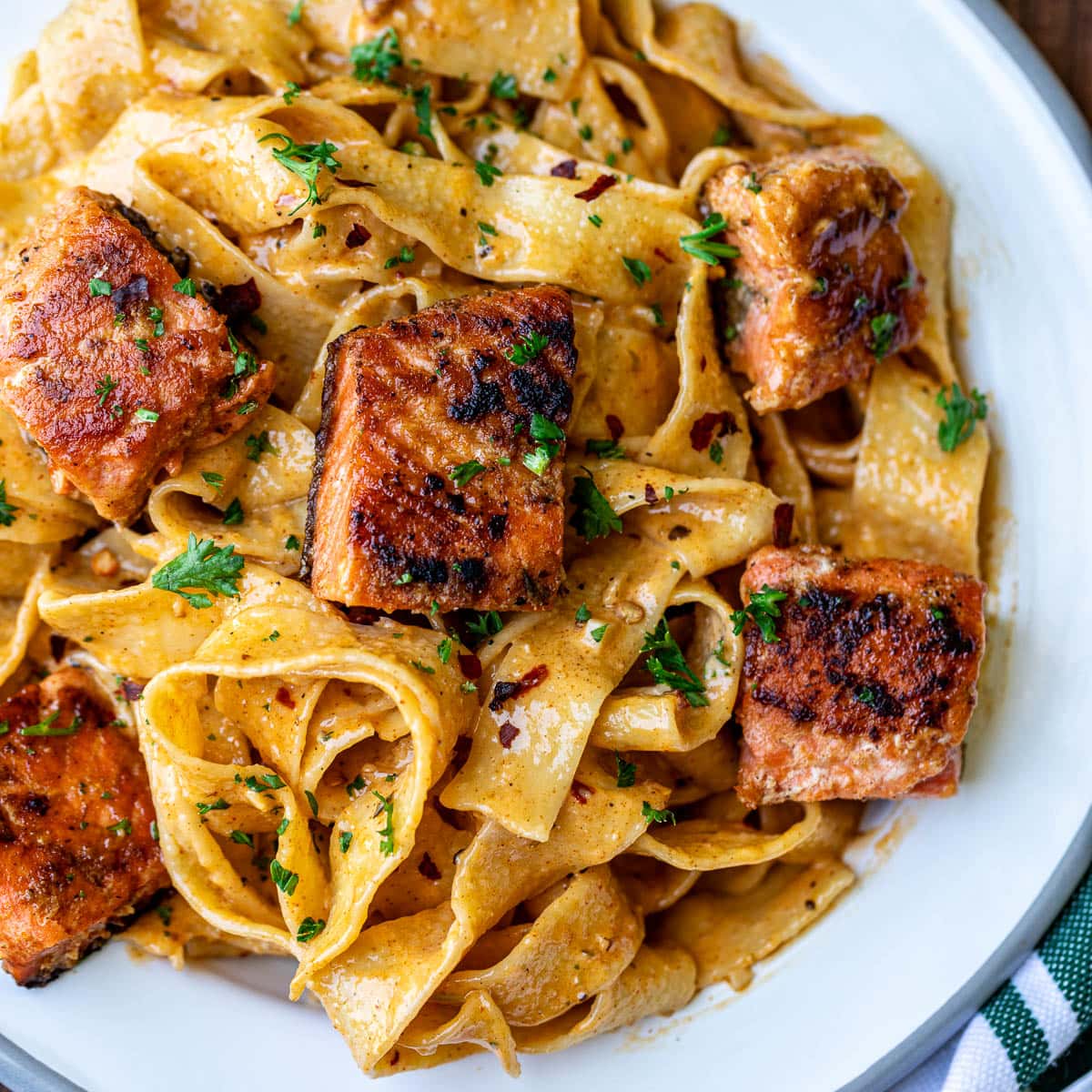Cajun Pasta With Salmon plated with fresh herbs.