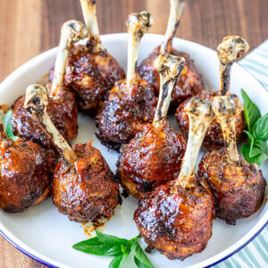 Plate of baked and glazed chicken lollipops.
