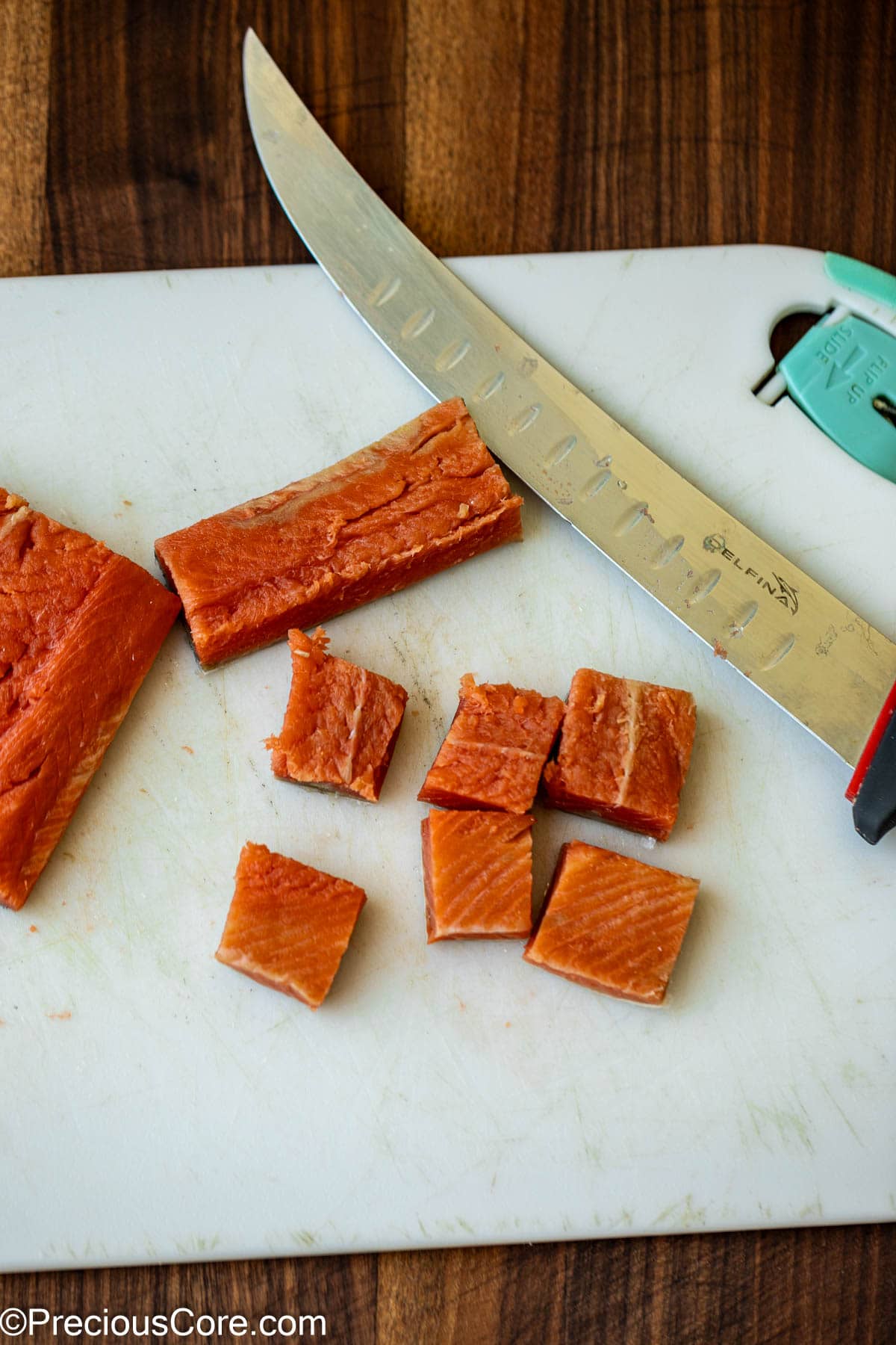 Cutting salmon into bite-sized pieces.