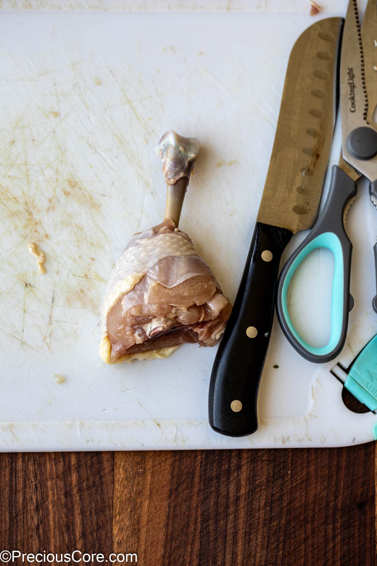 Knife, kitchen shears, and a chicken drumstick.