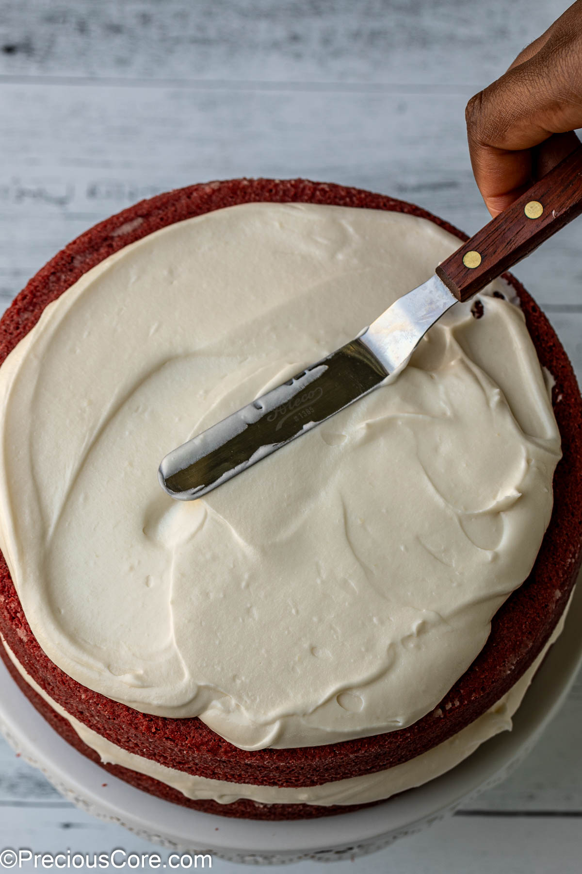 Frosting on the second layer of cake.