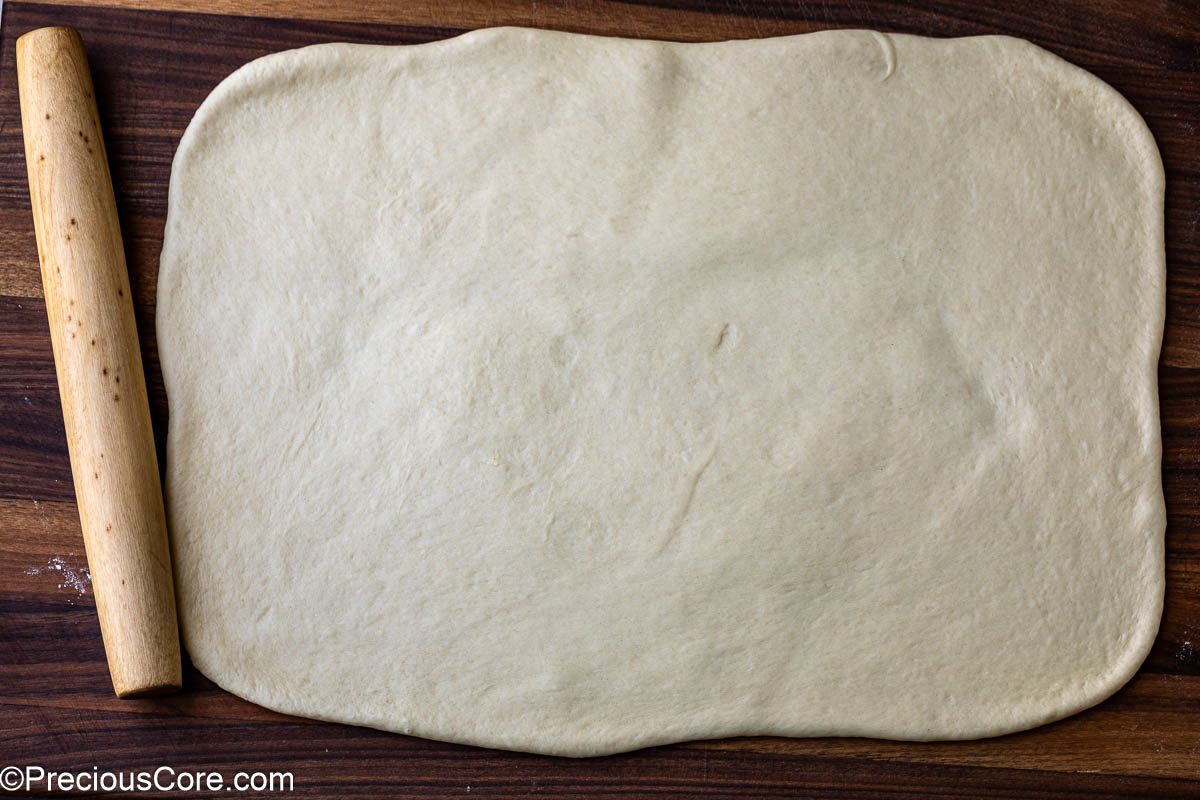 Cinnamon roll dough rolled into a rectangle.