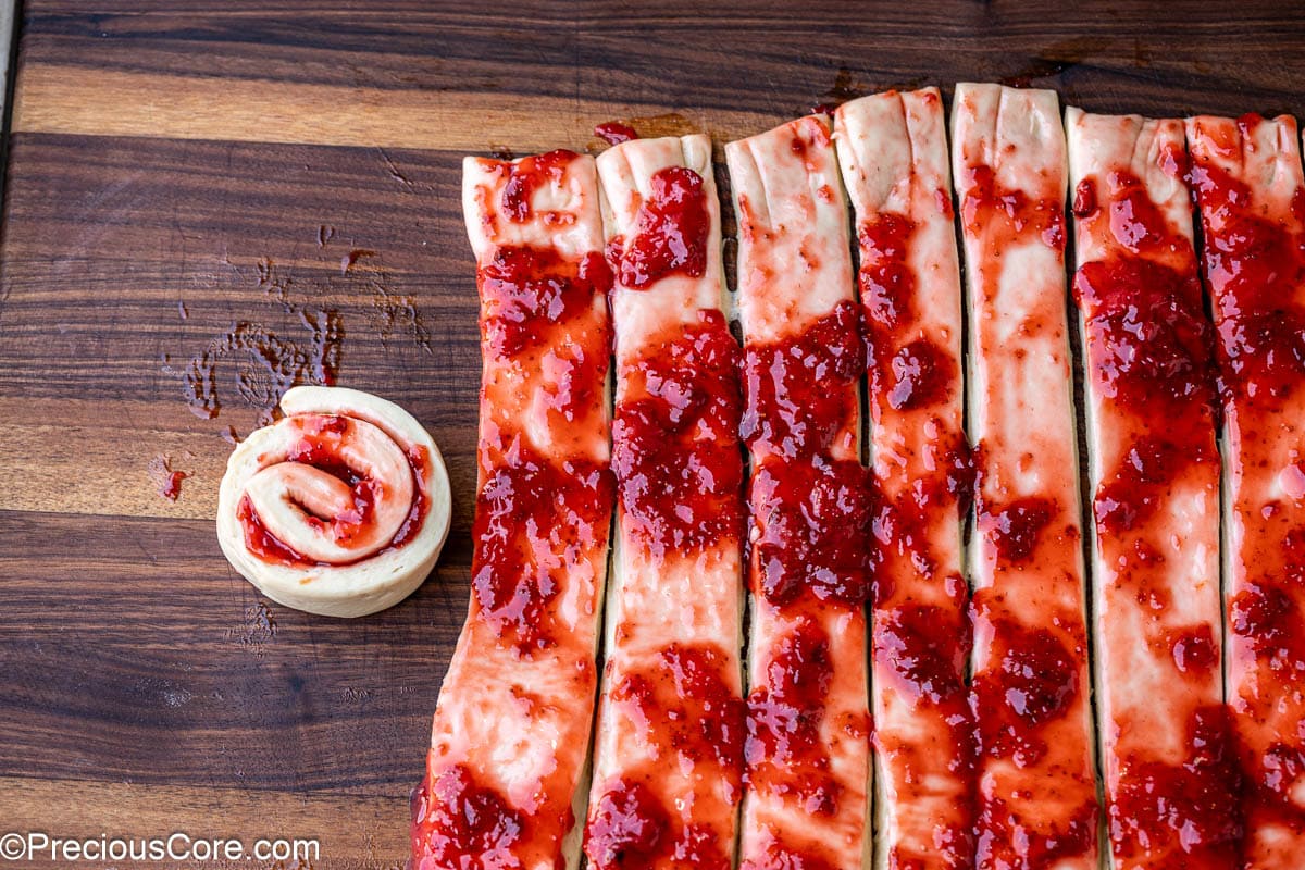 Rolling a strawberry cinnamon bun.