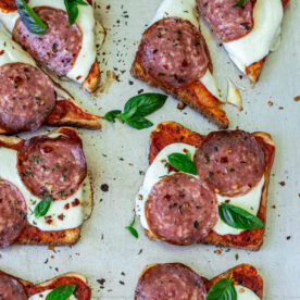 Pizza toast garnished with fresh basil.