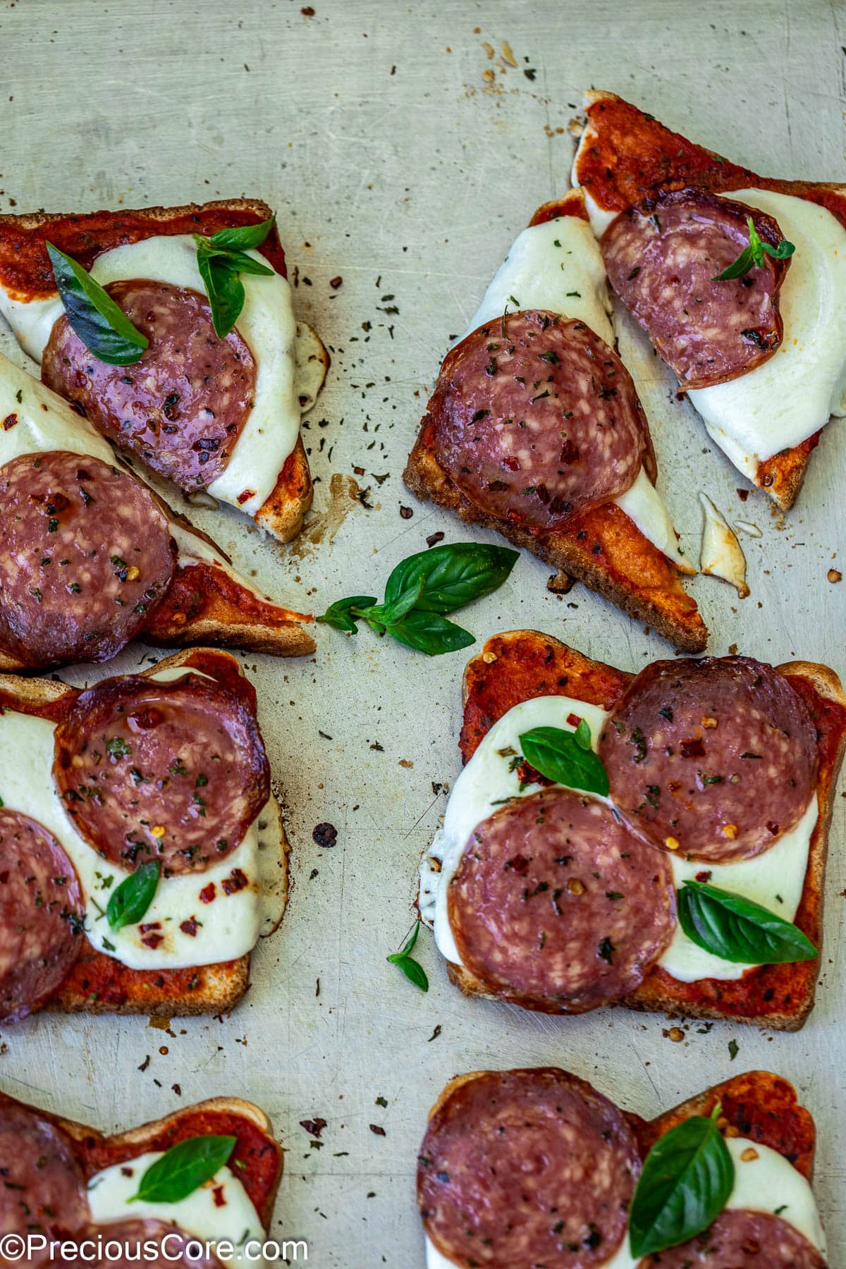 Pizza toast garnished with fresh basil.