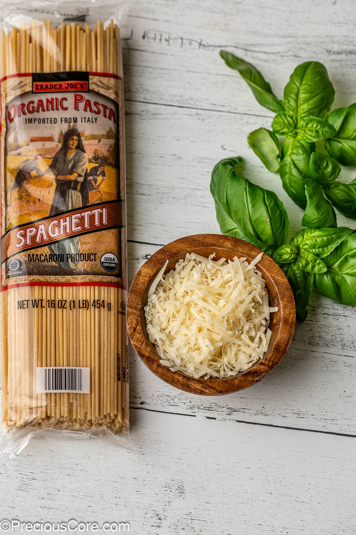 Spaghetti, shredded parmesan cheese and basil leaves.