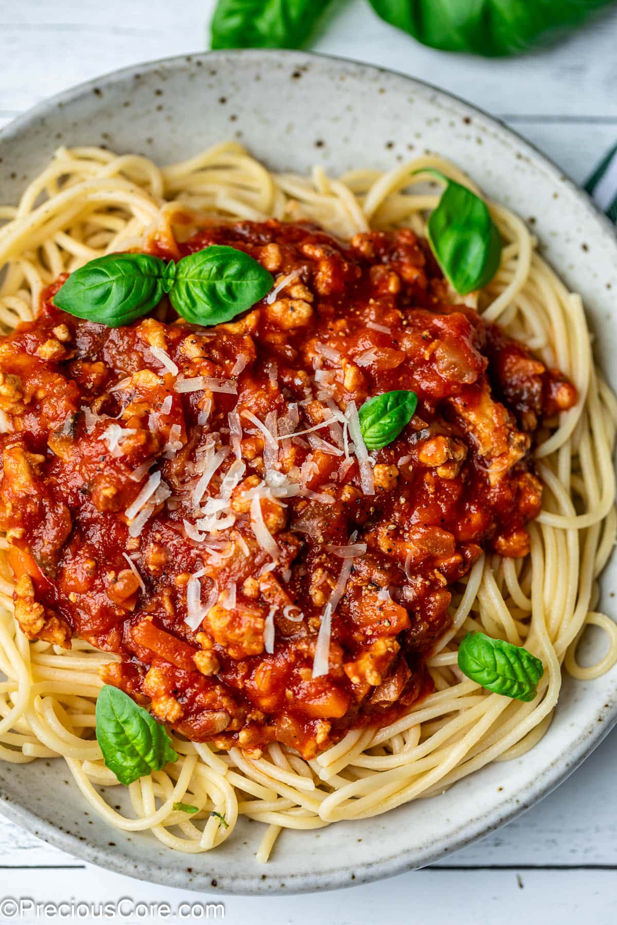 Spaghetti in a bowl topped with chicken Bolognese sauce.