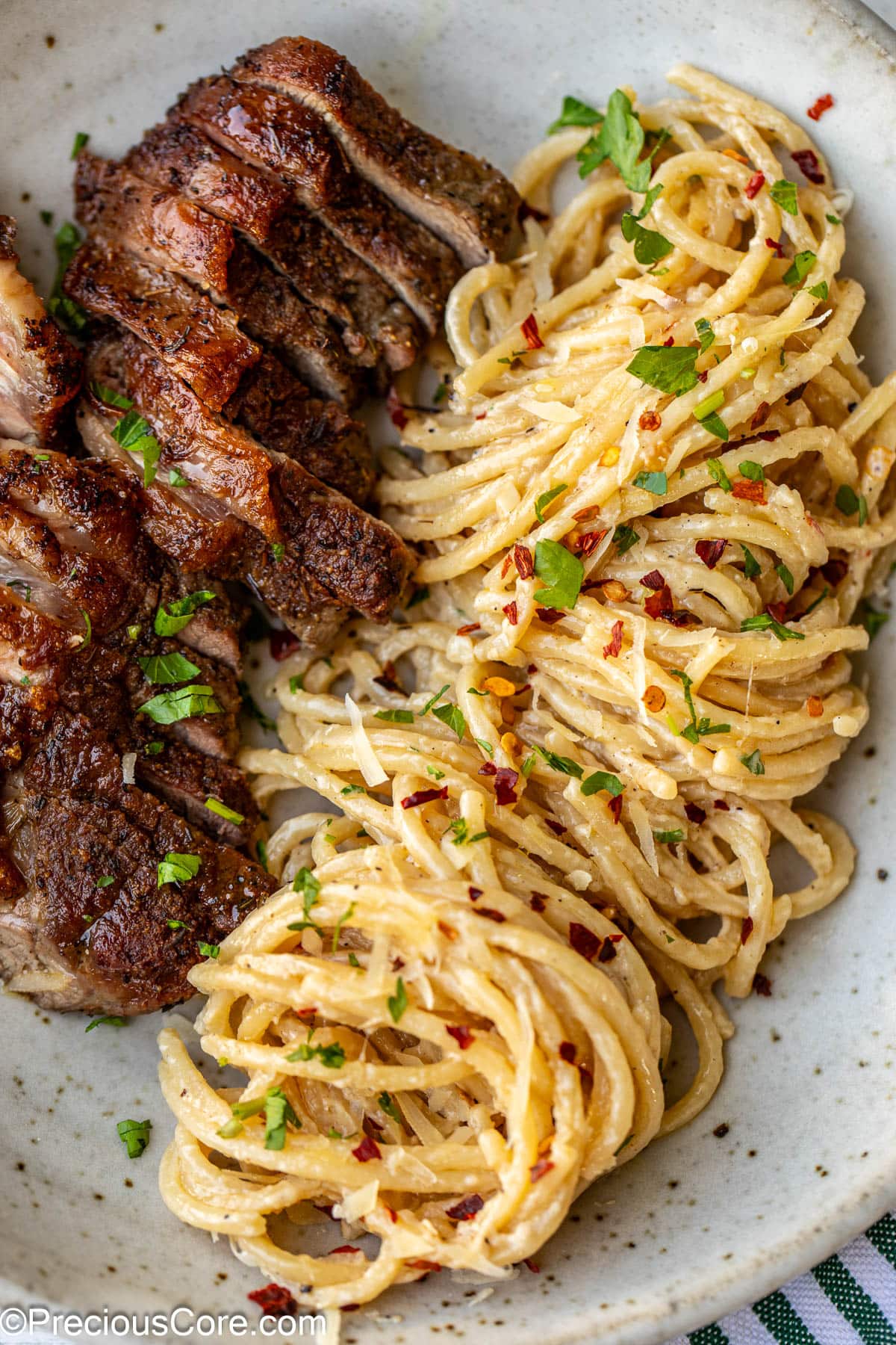 Sliced steak with cooked spaghetti in a bowl.