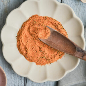 Wooden spoon in a plate of Cajun seasoning substitute.