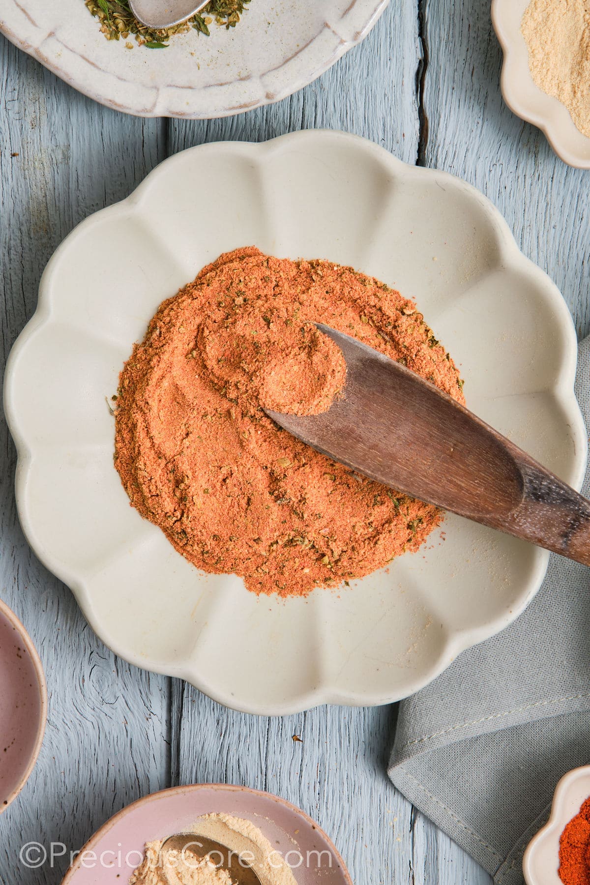 Wooden spoon in a plate of Cajun seasoning substitute.