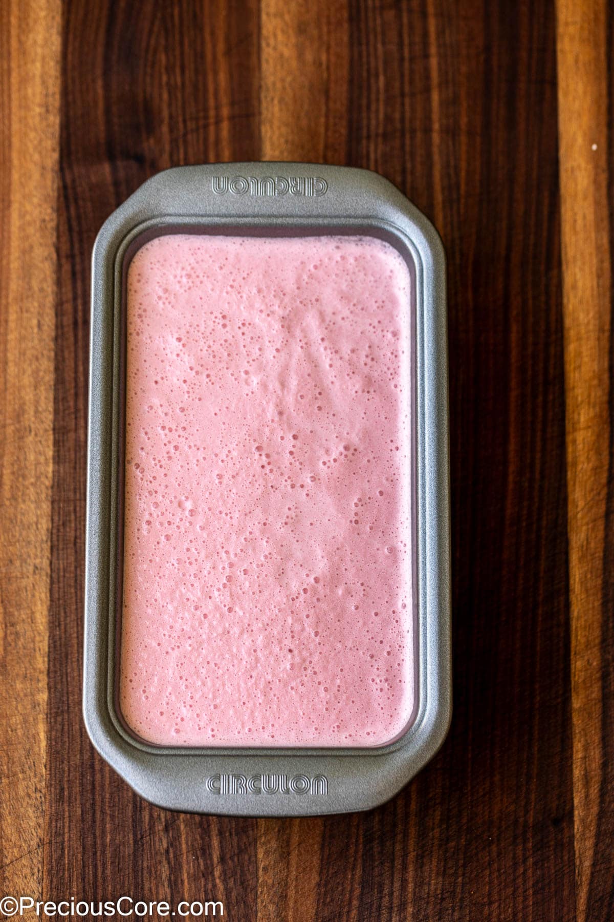 Watermelon ice cream mixture in a loaf pan.