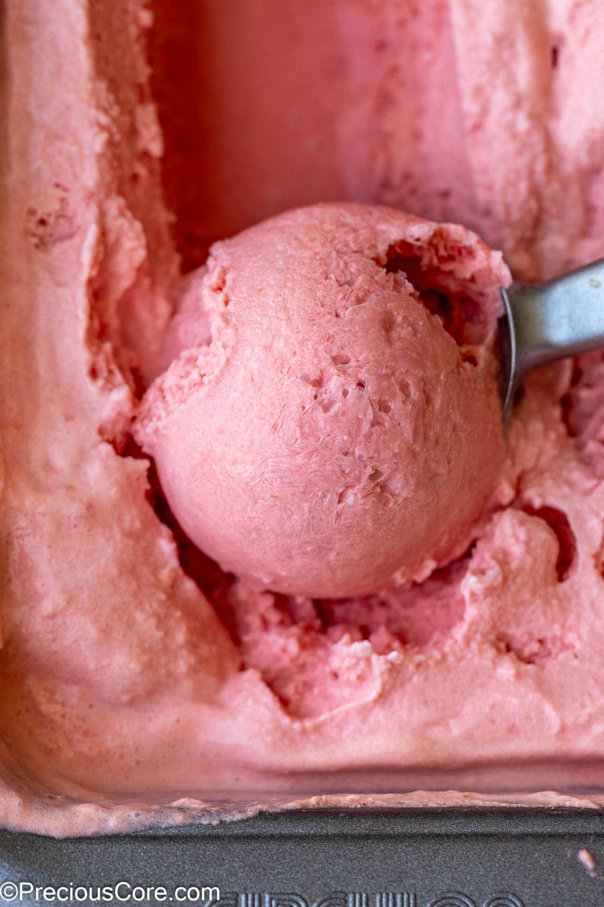 Scooping creamy watermelon ice cream.