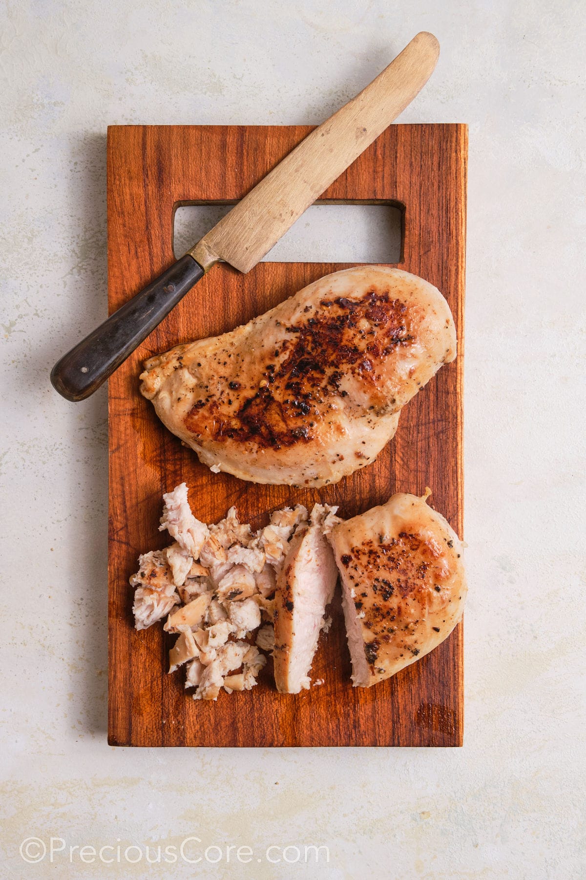 Dicing chicken breasts into small pieces.