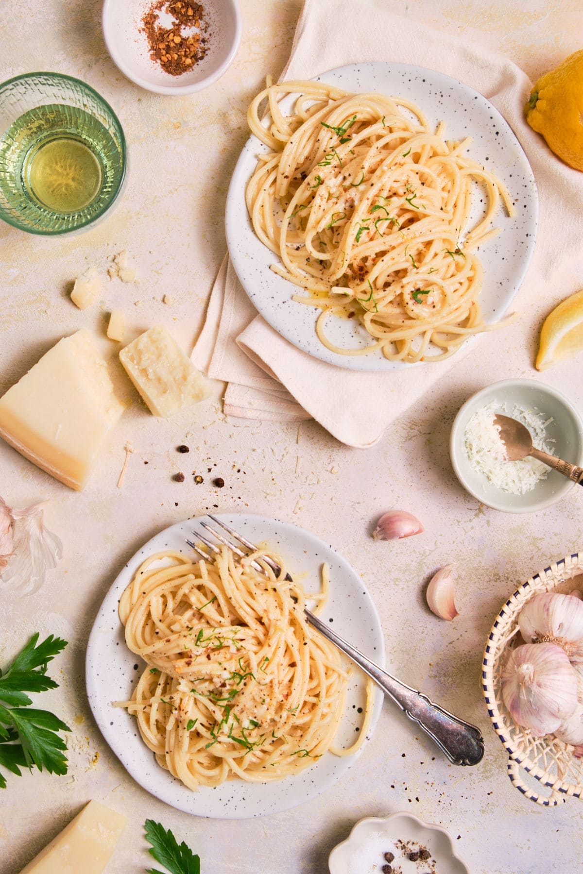 Two plates of pasta topped with grated parmesan.