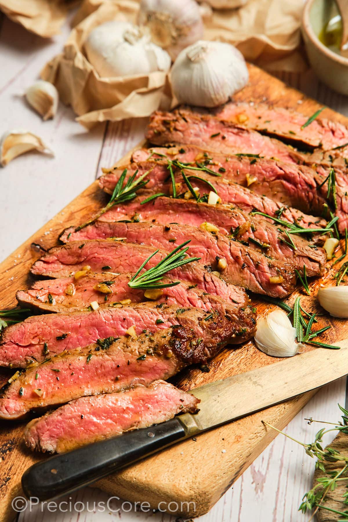 Sliced pan seared flank steak on a cutting board.