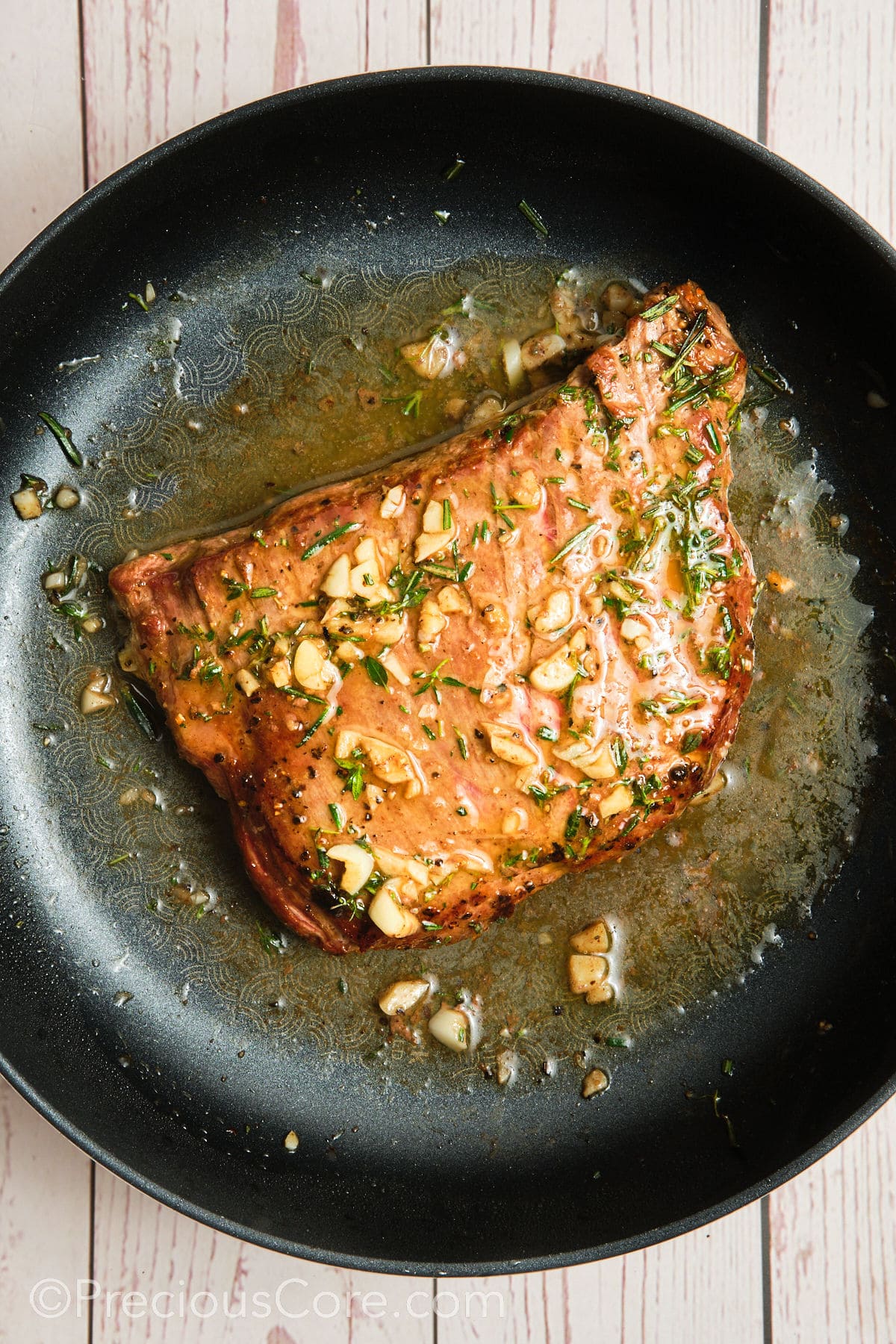 Pan seared flank steak with garlic herb butter sauce.