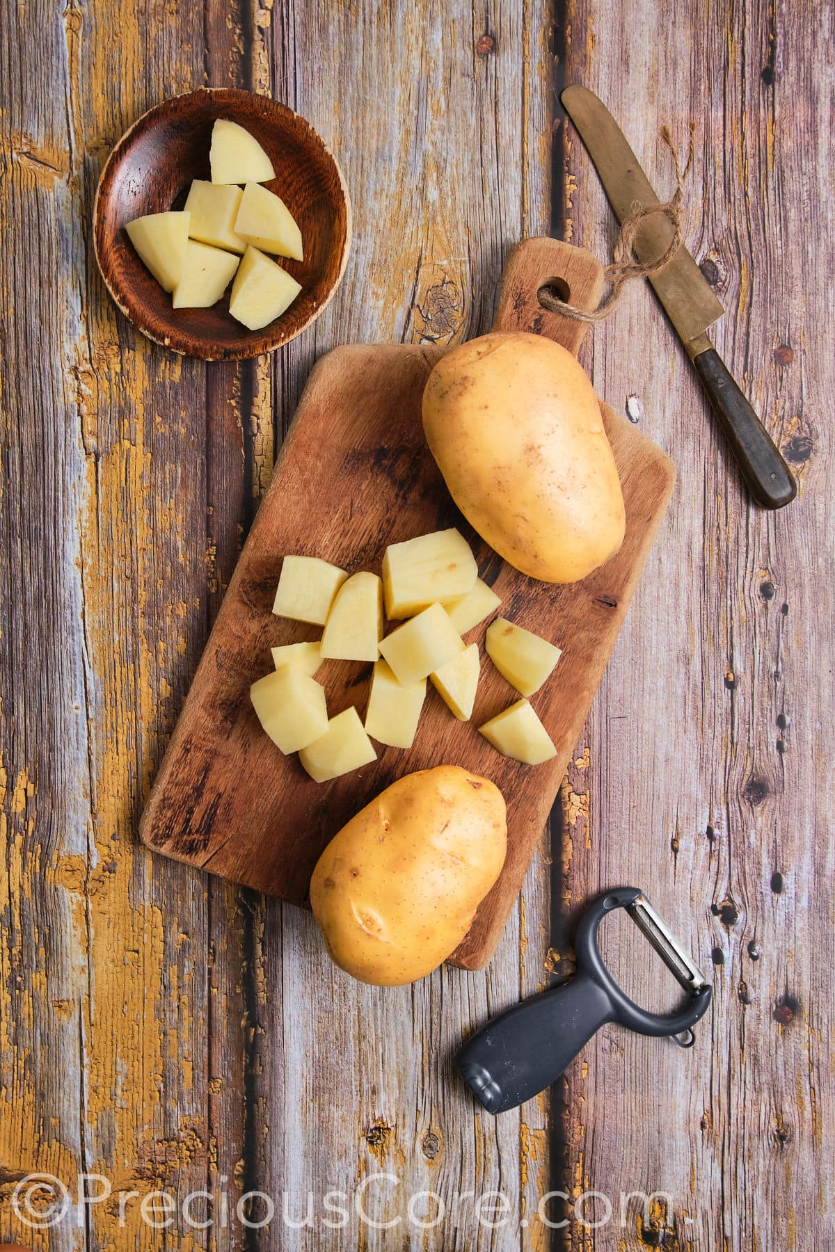 Peeling potatoes on a chopping board.