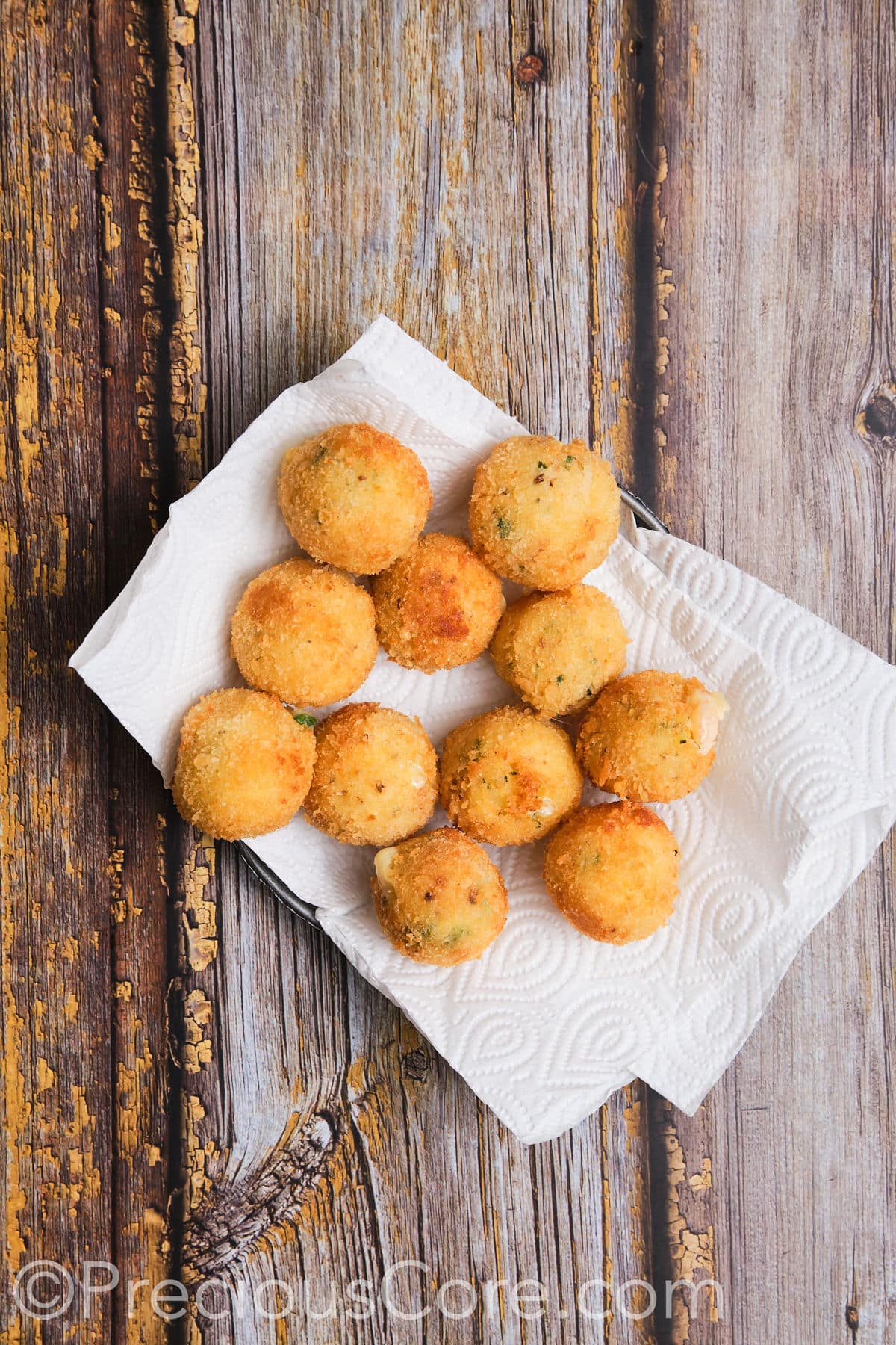 Cheesy potato balls on paper towels.