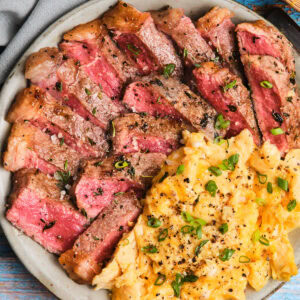 Close-up of Steak and Scrambled Eggs on a plate.