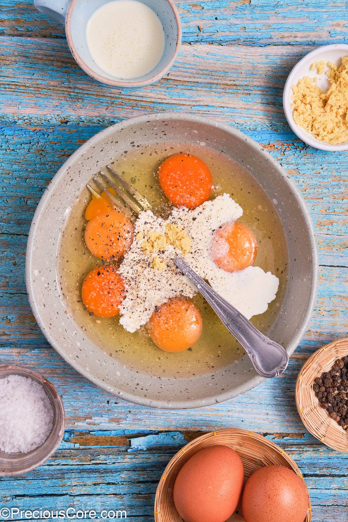 Cracked eggs, heavy cream and seasoning in a bowl.