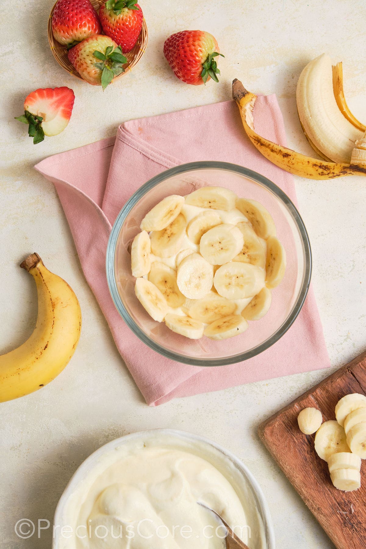 Adding a layer of bananas to pudding.