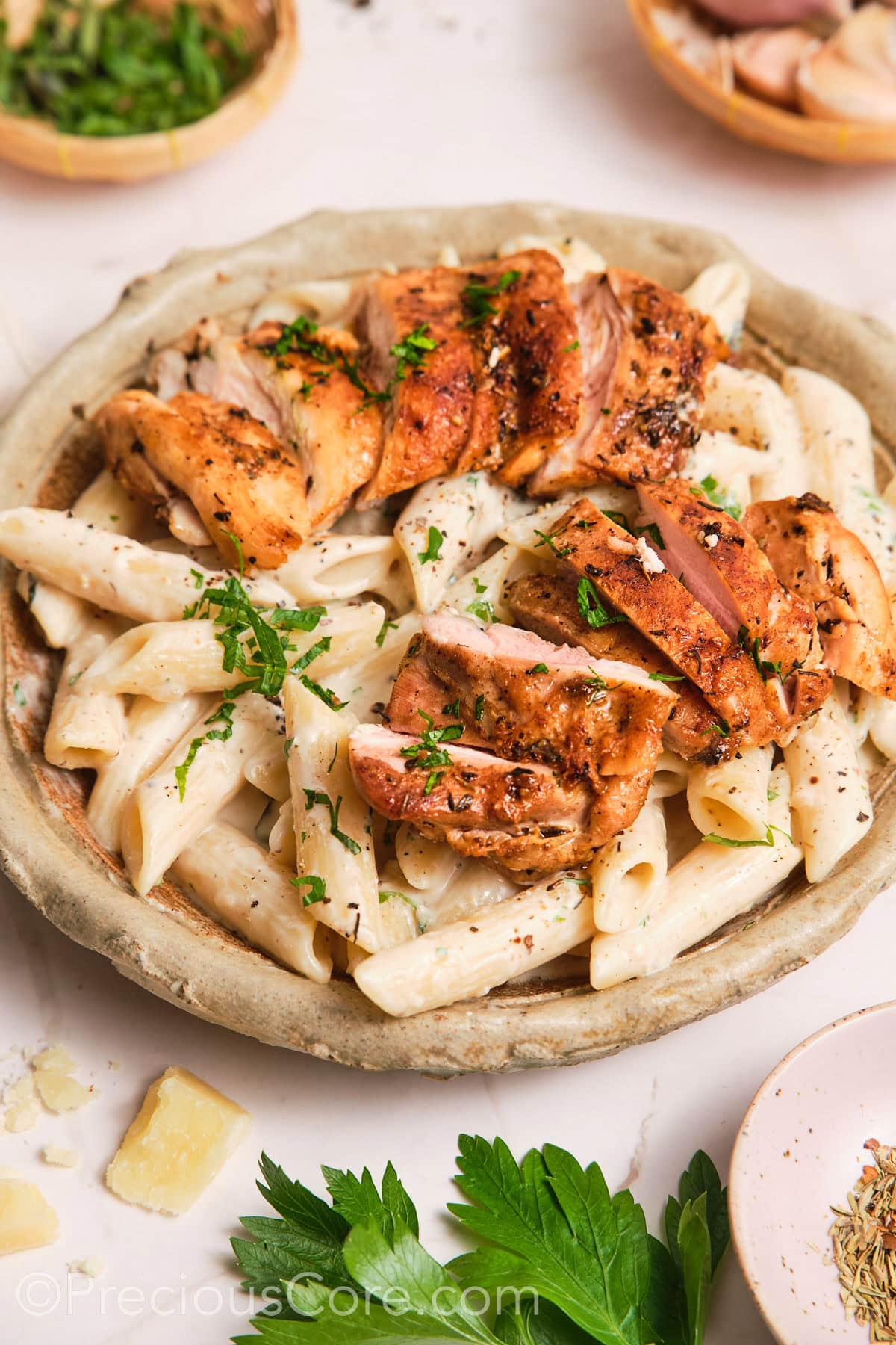 Creamy pasta in a bowl, topped with pan-seared chicken.