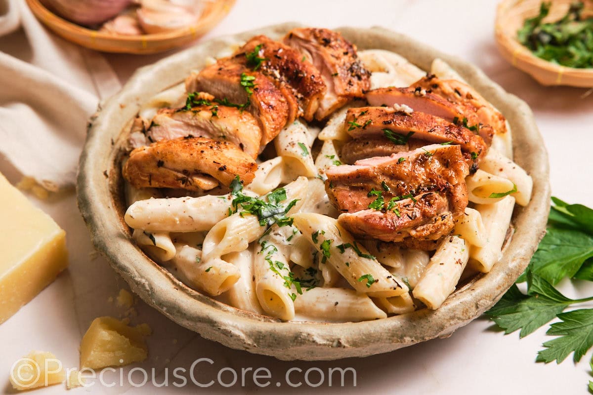 Creamy pasta topped with sliced boneless chicken thighs.