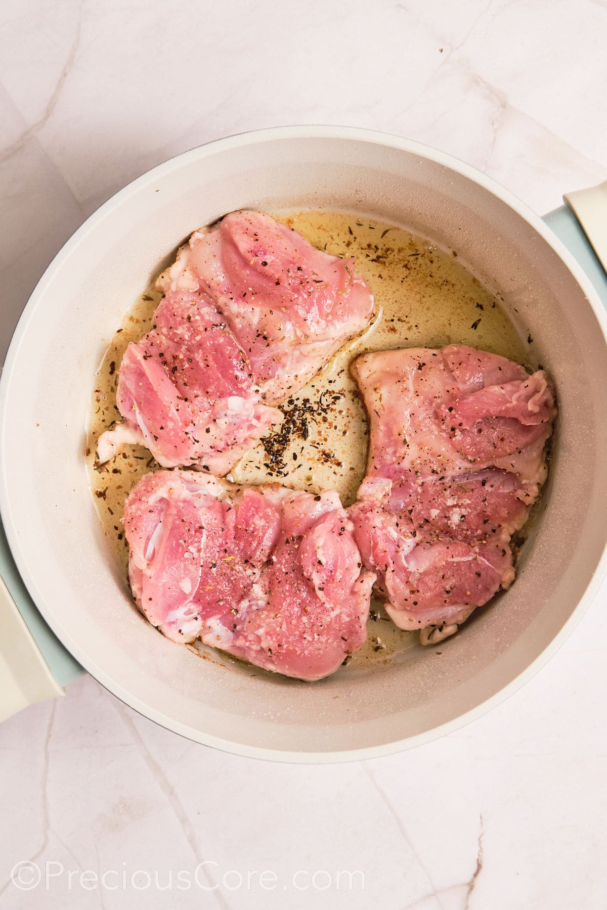 Boneless chicken thighs cooking in a pot.