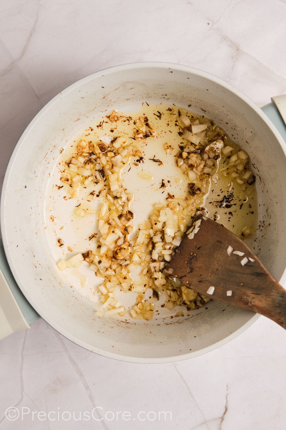 Sautéing onions and garlic in a pot.