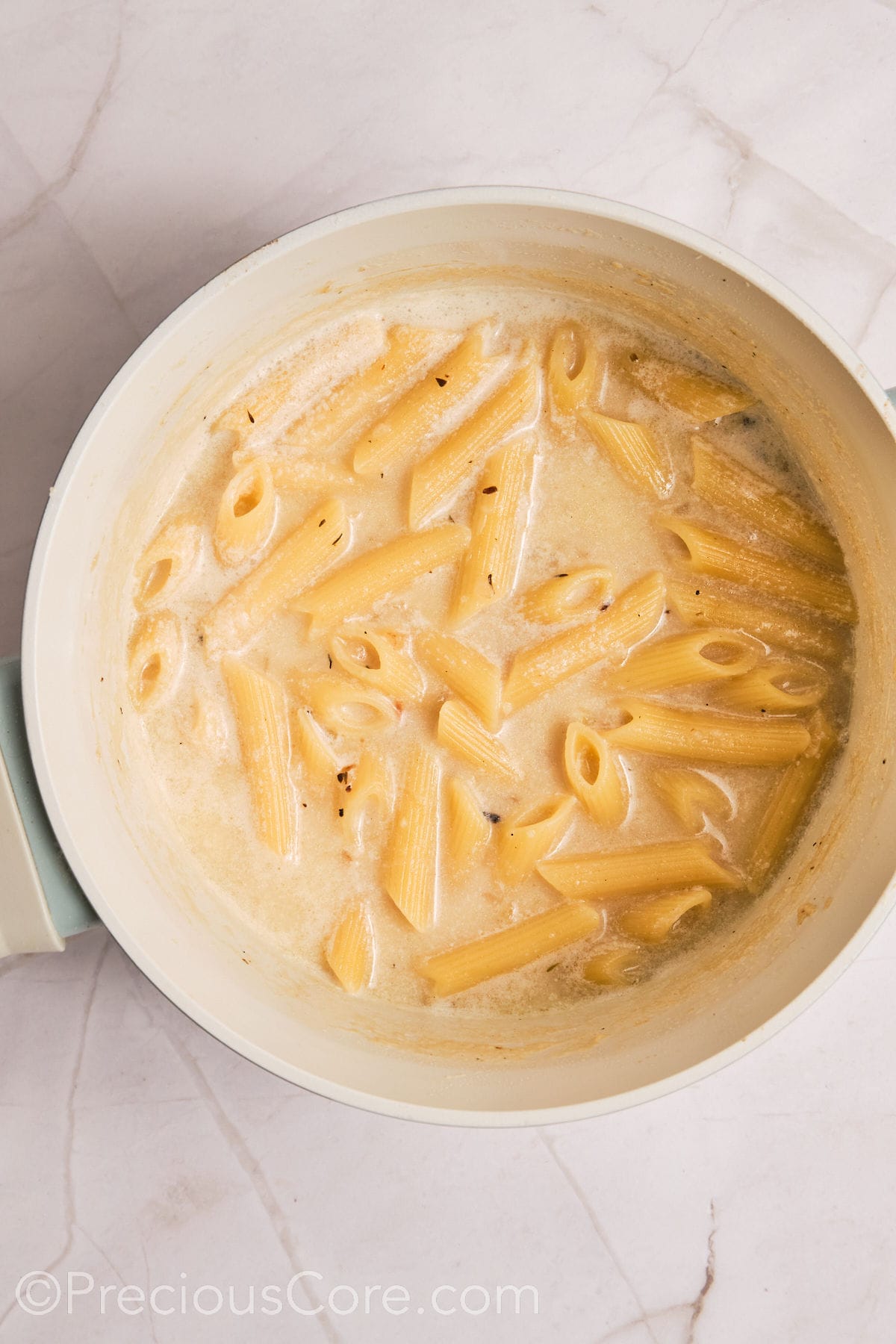 Pasta added to creamy liquid.