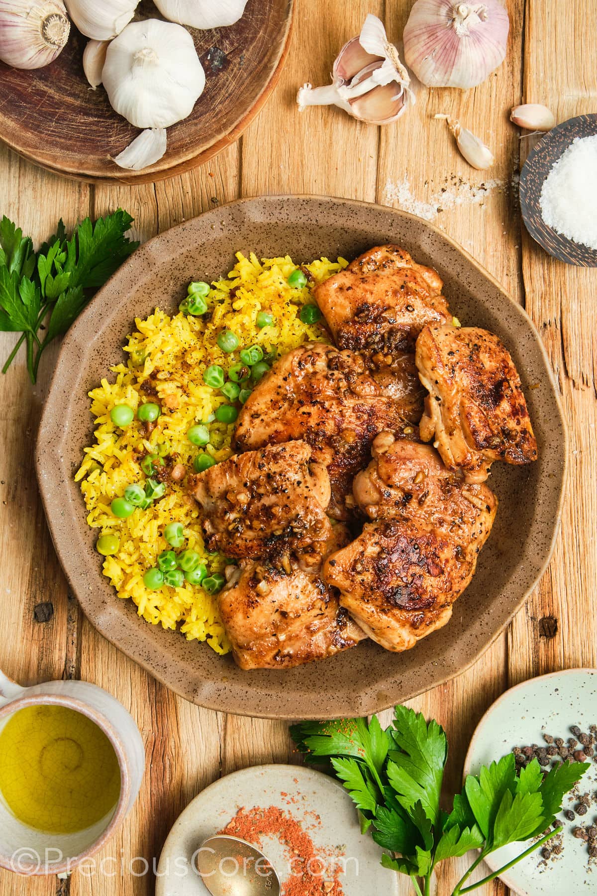 Glistening golden chicken thighs in a bowl with rice.